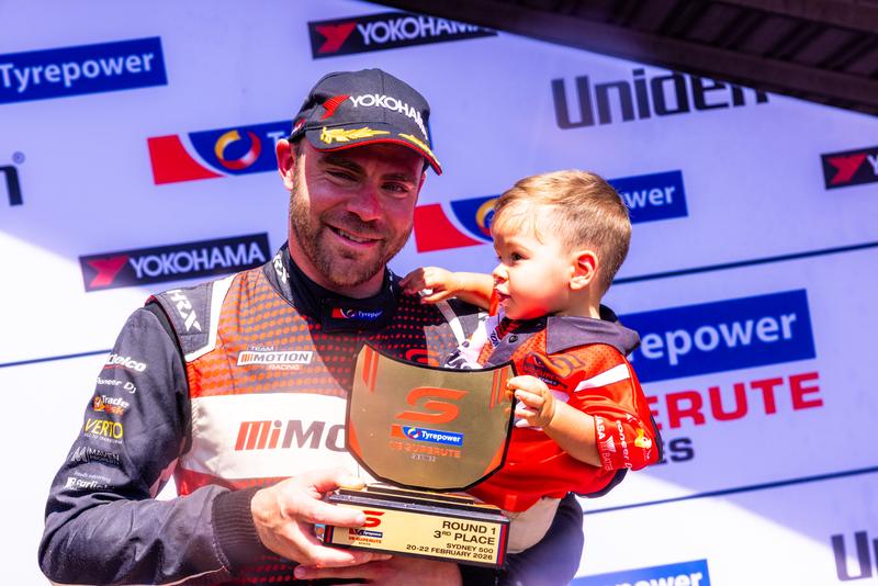 Aaron on the Sydney 500 podium with his Round 1 trophy and his son